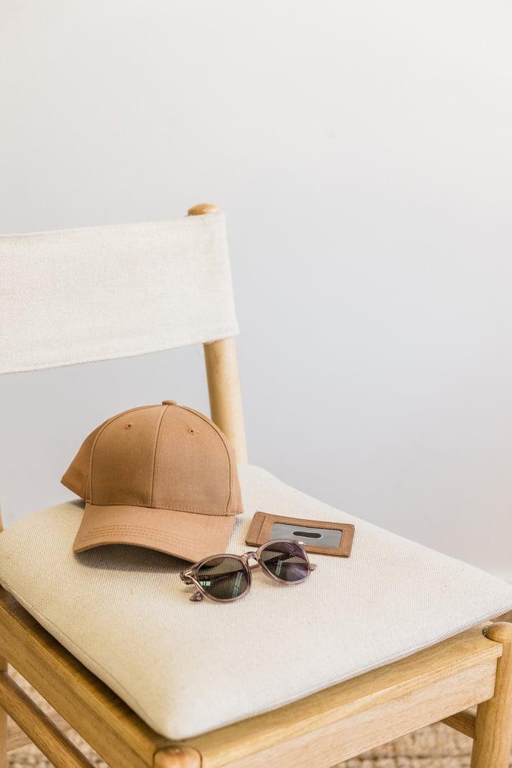 Cap, Sunglasses and Leather Wallet on Chair